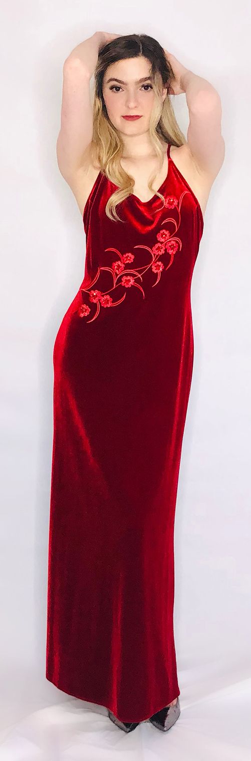 model in red velvet gown with spaghetti straps and embroidered flowers at front